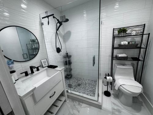 a bathroom with a shower and a sink and a toilet at Palm Beach Paradise in West Palm Beach