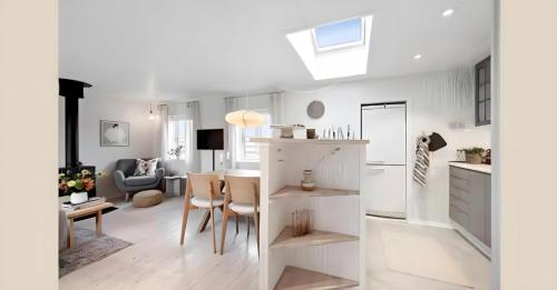 a kitchen and living room with a table and chairs at Nordenhus in Nyborg