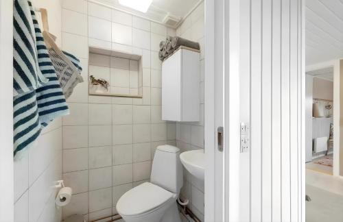 a white bathroom with a toilet and a sink at Nordenhus in Nyborg
