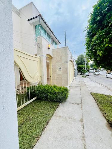 a building with a fence next to a sidewalk at Venator House Habitación doble #19 in Miravalle