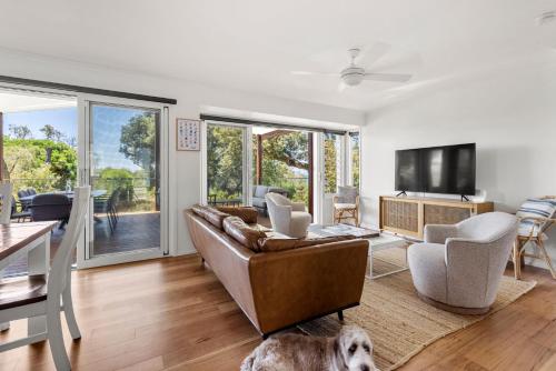a living room with a couch and a dog at Surfspray I Pet Friendly I Absolute Beachfront in Culburra Beach