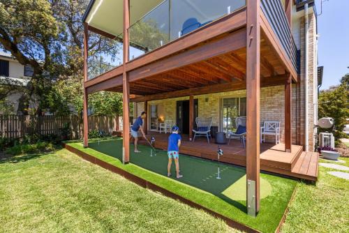 two people playing a game of miniature golf on a lawn at Surfspray I Pet Friendly I Absolute Beachfront in Culburra Beach