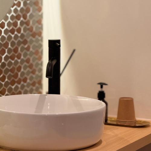 a white bowl on top of a bathroom sink at Shiki Villa Beppu in Beppu