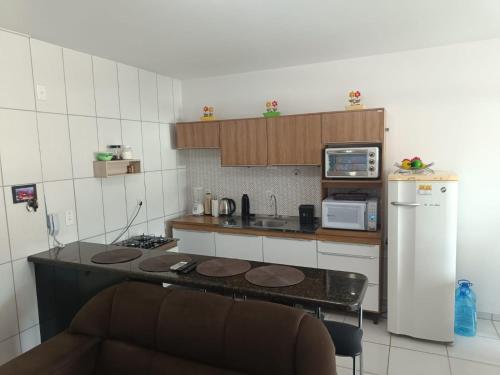 a small kitchen with a counter top and a refrigerator at Apartamento no Mar Grosso em Laguna SC. in Laguna