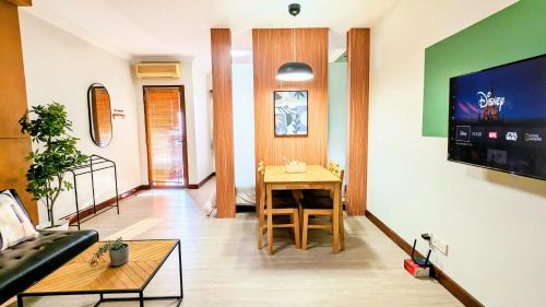 a living room with a table and a couch at Cottonwood Midcentury Apartment at Majesty 811 in Bandung