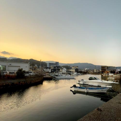 a group of boats docked in a harbor at sunset at Shiki Villa Beppu in Beppu
