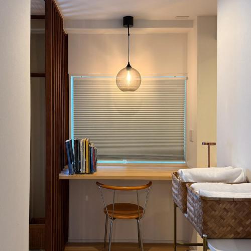 a room with a window with a chair and a lamp at Shiki Villa Beppu in Beppu