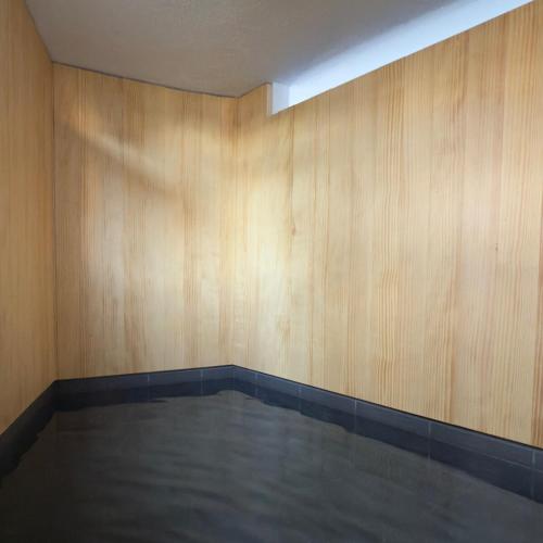an empty room with wood walls and a pool at Shiki Villa Beppu in Beppu