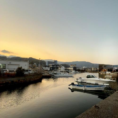 a group of boats docked in a harbor at sunset at Shiki Villa Beppu in Beppu