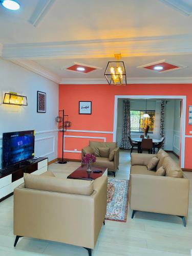 a living room with couches and a flat screen tv at The Blue Resort in Yaoundé