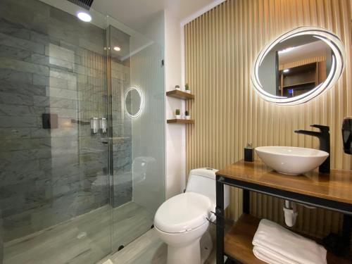 a bathroom with a toilet and a sink and a shower at Epic Suites x Ahead in Pereira