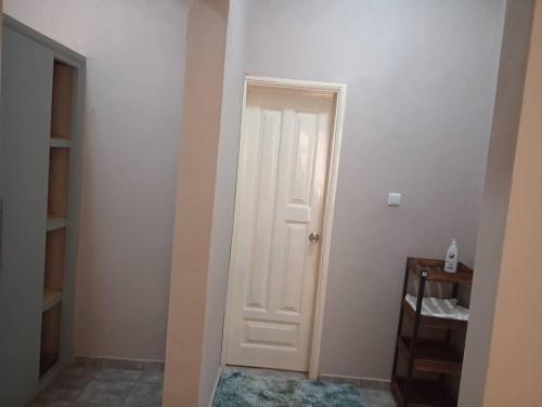 a white door in a room with a shelf at The Blue Resort in Yaoundé