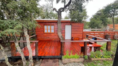 a wooden cabin with a white door in a yard at alojamientos CM in Tolhuin