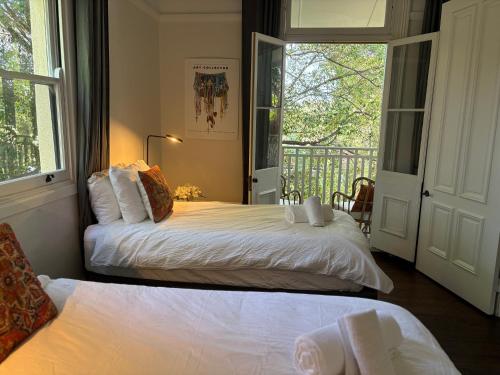 a bedroom with two beds and a balcony at Light filled terrace flat in Sydney