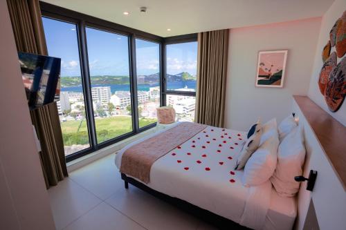 a bedroom with a bed with a large window at Gorgeous 2 bedroom, 17th floor, with breathtaking view, Fourteen at Mullet Bay in Cupecoy