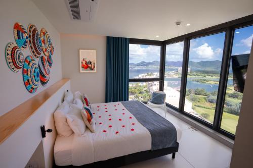 a bedroom with a bed and large windows at Gorgeous 2 bedroom, 17th floor, with breathtaking view, Fourteen at Mullet Bay in Cupecoy