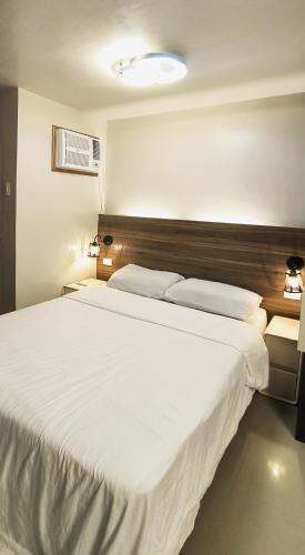 Un dormitorio con una gran cama blanca en una habitación. en Bee Homestay Urban Deca Homes Tipolo, Mandaue City Cebu, en Mandaue
