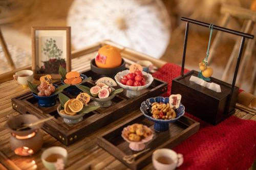 een dienblad met eten op tafel met snacks bij Zhangjiajie Valley Love Original Ecological Hotel - Free pick-up and drop-off Service - 24-hour Self-service coffee - Ice Cubes - Outdoor viewing Platform - Self-service laundry room Dryer - Free photography service in Hotel area in Zhangjiajie