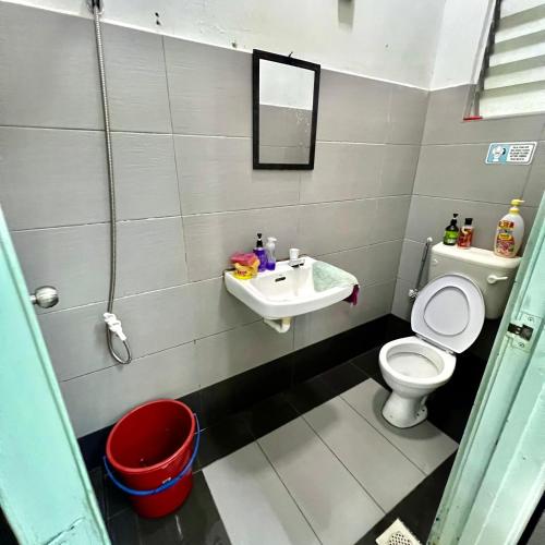 a bathroom with a toilet and a sink at DI TAMBAK 2 Homestay in Pontian Kecil