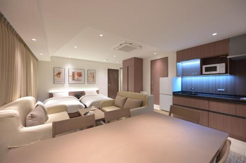 東京にあるCOCOYO Hotel 大塚の部屋にソファとテーブルがあるリビングルーム