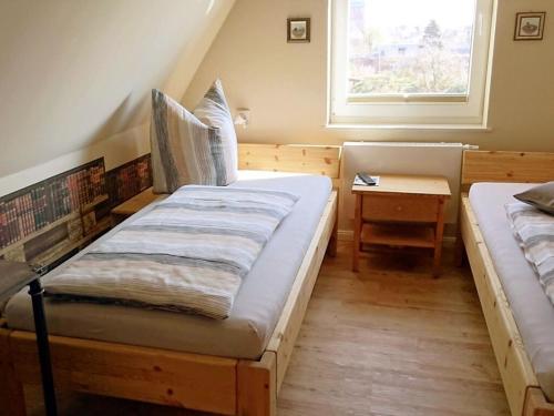 a bedroom with two beds and a window at Tönnihuus Comfortable holiday residence in Tönning