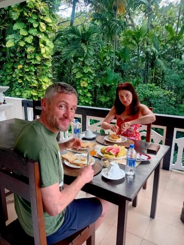 a man and a woman sitting at a table eating food at Green turf in Galle