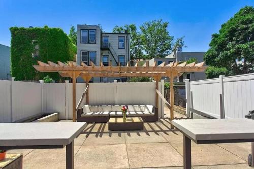 a patio with a wooden pergola and a white fence at Jersey City Retreat w Private Backyard Bonfire Near NYC in Jersey City
