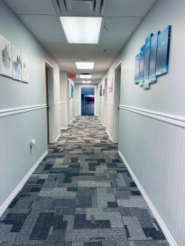 an empty hallway in an office building with a tile floor at Elite Hotel -Downtown Center- "Ski & Northern light Tour" "Hot Spring Tour "Long-term stay" in Whitehorse