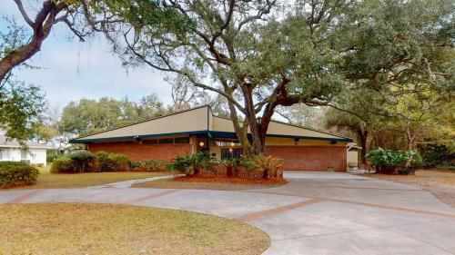 a red brick building with a tree in front of it at GREAT DUNES COTTAGE home in Jekyll Island