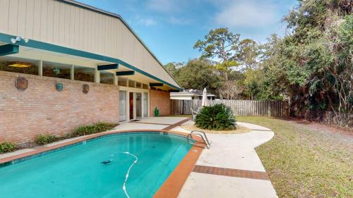 a swimming pool in front of a house at GREAT DUNES COTTAGE home in Jekyll Island