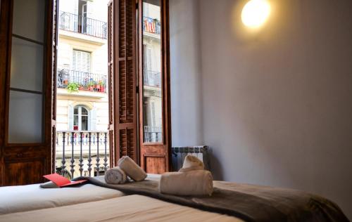 a bedroom with a bed and a window with a view at Happy People Plaza España Apartments in Barcelona