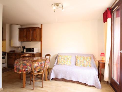 - une cuisine avec une table et un lit dans une chambre dans l'établissement Charmant F2 avec balcon ouest, parking et ascenseur, à 650m des thermes et commerces, classé 2 étoiles** - FR-1-415-7, à Le Mont-Dore