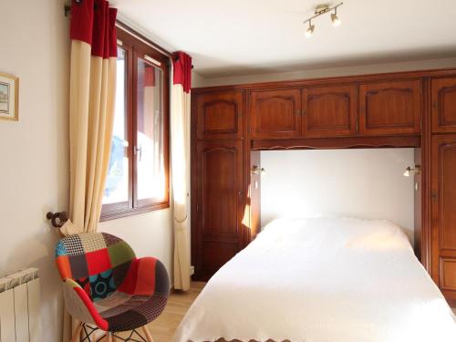 une chambre avec un lit, une chaise et une fenêtre dans l'établissement Charmant F2 avec balcon ouest, parking et ascenseur, à 650m des thermes et commerces, classé 2 étoiles** - FR-1-415-7, à Le Mont-Dore