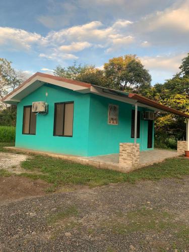 a small house with a green at Hospedaje Oropendola Nest in Bagaces