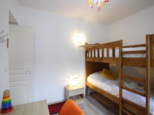 une chambre avec deux lits superposés et une table dans l'établissement Bel F4 au 2ème étage sans ascenseur, centre Mont-Dore, 3 chambres, bien équipé, capacité 6 pers - FR-1-415-24, à Le Mont-Dore