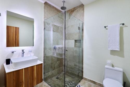 a bathroom with a shower and a sink and a toilet at Infinity Pool rooftop wifi Tulum in Tulum