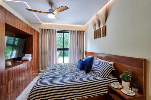 a bedroom with a bed with blue pillows and a window at Infinity Pool rooftop wifi Tulum in Tulum