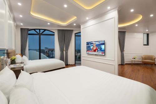 a bedroom with a white bed and a tv at Success Airport Hanoi Hotel in Phu Lo Dong