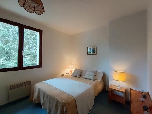 une chambre avec un lit avec deux oreillers dessus dans l'établissement Maison familiale à 750m de la plage, jardin et parking privé - FR-1-364-84, à Saint-Brévin-les-Pins