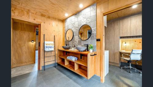 a bathroom with a sink and a mirror on the wall at Luxury on Lake Tinaroo Lakefront Living in Yungaburra