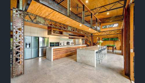 an open kitchen with a bar and a dining area at Luxury on Lake Tinaroo Lakefront Living in Yungaburra