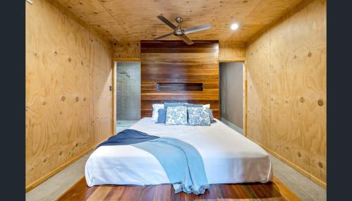 a bedroom with a bed with a ceiling fan at Luxury on Lake Tinaroo Lakefront Living in Yungaburra