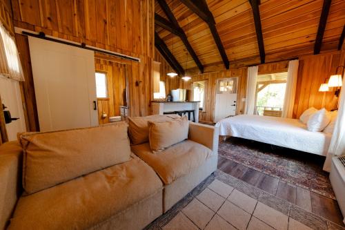 a living room with a couch and a bed at Peaceful Creekside Tiny Cabin, Family Adventure Near Waterfalls in Smithville