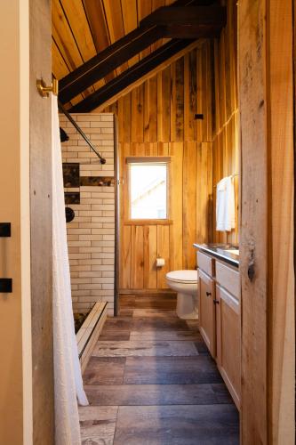 a wooden bathroom with a toilet and a window at Cozy Creekside Cabin Near Waterfalls, Hiking, Fire Pit in Smithville