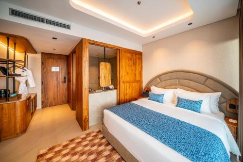 a bedroom with a large bed with a blue blanket at TUI BLUE Berawa Hotel and Villas in Canggu