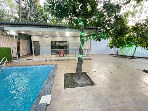 uma árvore com uma fita verde ao redor ao lado de uma piscina em Heritage Villa em Thane
