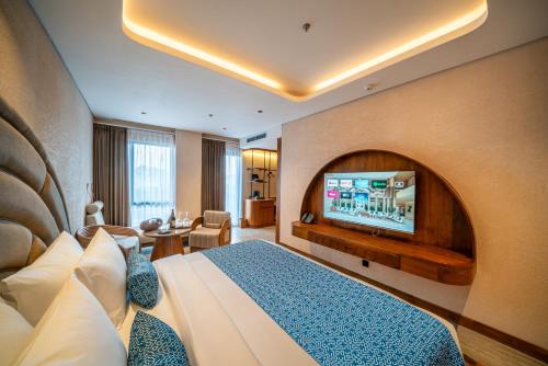 a hotel room with a bed and a flat screen tv at TUI BLUE Berawa Hotel and Villas in Canggu