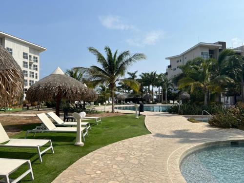a resort with a pool and chairs and a resort at Refugio caracol in Claridad