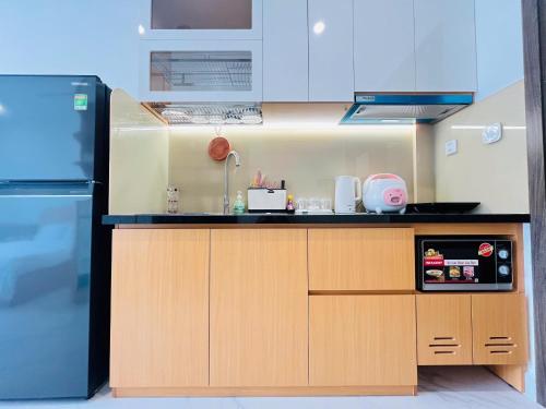 Il comprend une cuisine équipée d'un comptoir et d'un réfrigérateur. dans l'établissement May Homes - Studio Beverly Vinhomes Grand Park, à Long Bình