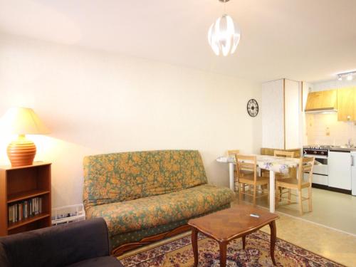 un salon avec un canapé et une table dans l'établissement Appartement F2 bis de 45m² avec balcon, parking et tout confort au Mont-Dore - FR-1-415-116, à Le Mont-Dore